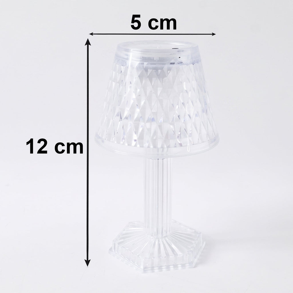 Small crystal table lamp creating a warm, ambient glow in a dark room.