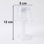 Small crystal table lamp creating a warm, ambient glow in a dark room.