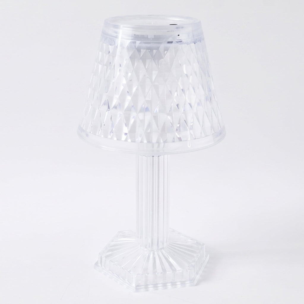 Modern LED crystal lamp displayed on a wooden shelf in a home setting.