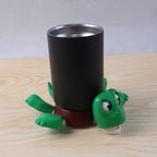 Plastic turtle coaster protecting a cup on a surface