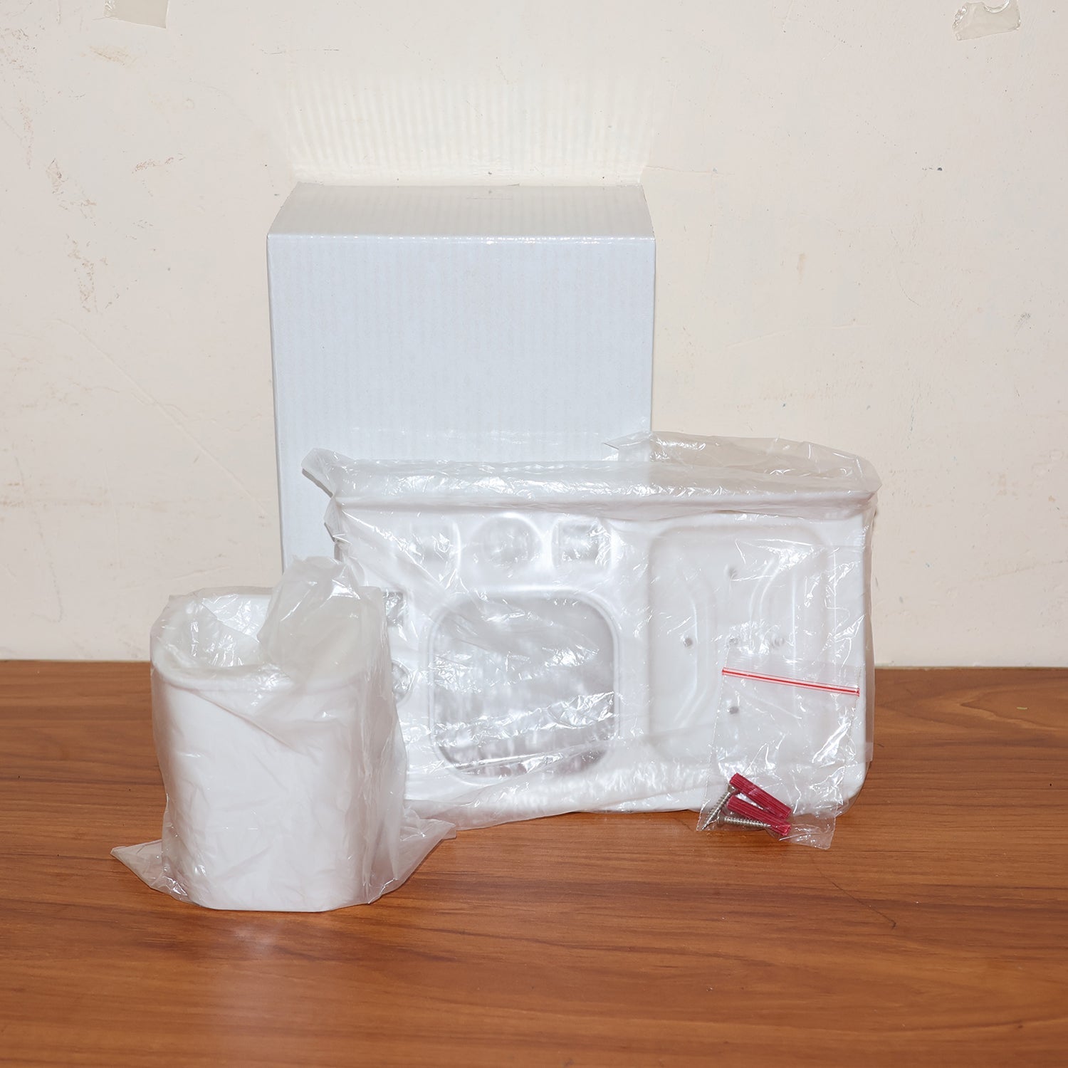 Lifestyle image of wall mounted toothbrush holder with toothbrush and toothpaste inside.