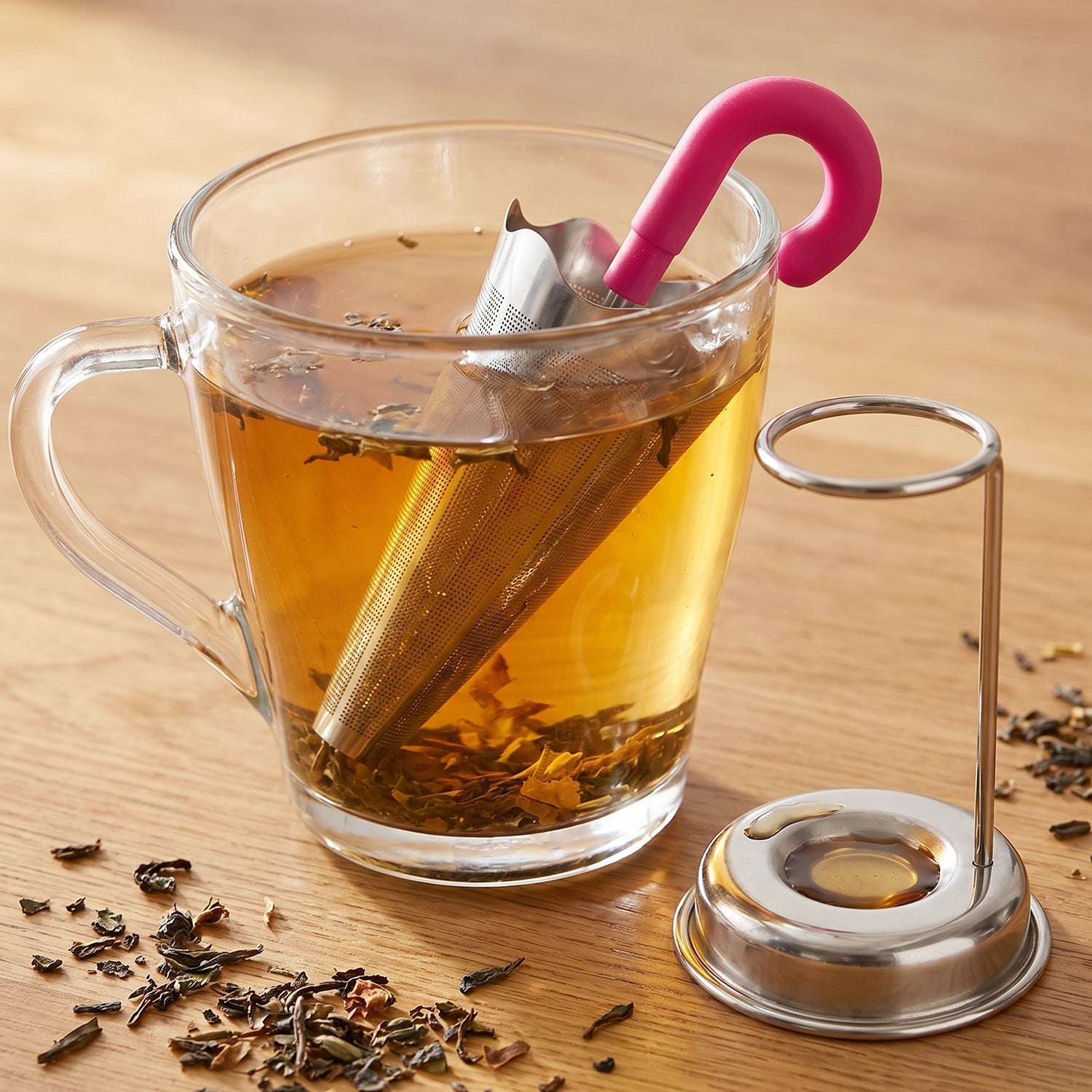 Umbrella tea strainer hooked on a ceramic teacup, brewing loose leaf tea for a perfect infusion.