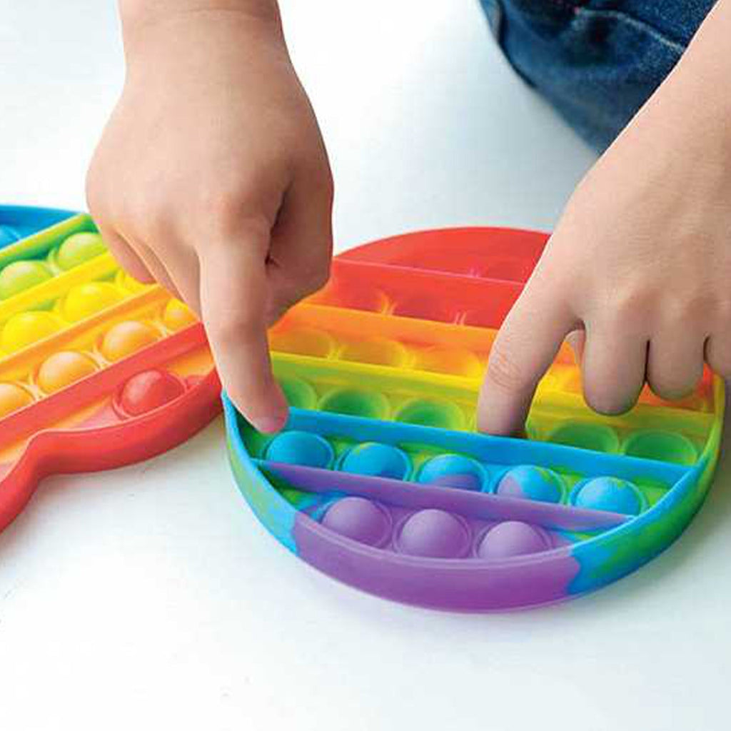 Child playing with rainbow colored sensory push bubble fidget toy