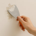 The putty knife demonstrating its flexibility and sturdy construction for various applications.