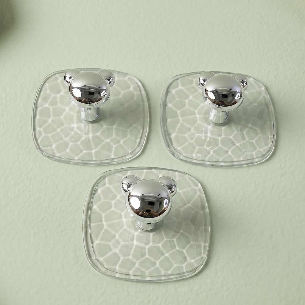 Clear adhesive wall hook holding a handbag in a hallway for convenient storage.