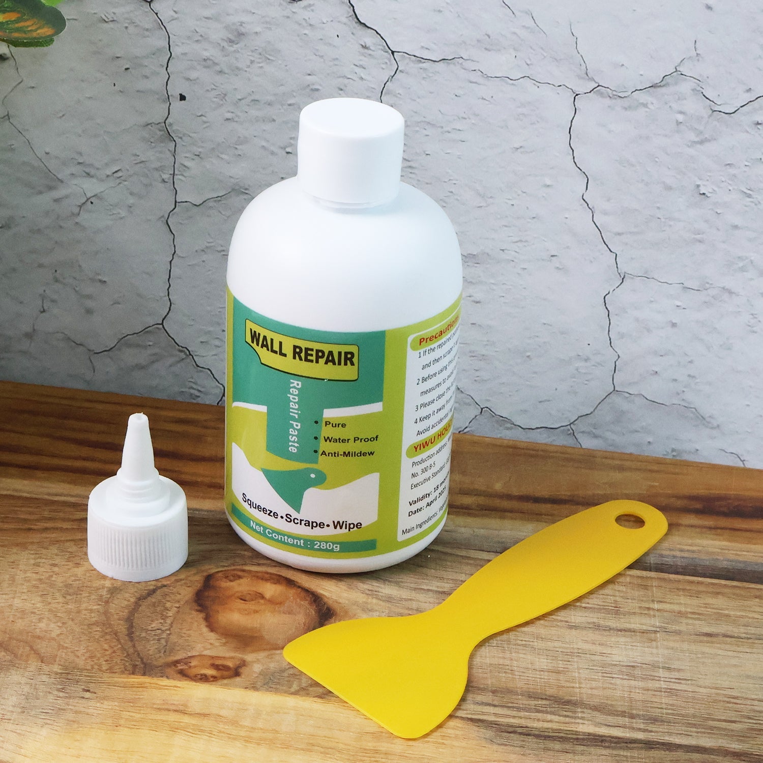 Hand applying waterproof wall filler cream to damaged wall surface