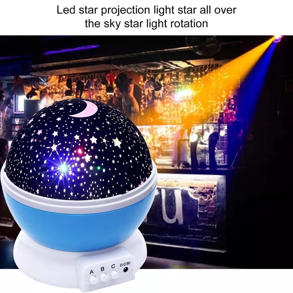 Star projector night lamp illuminating a dark room with celestial patterns.