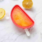 Hand holding a perfectly formed watermelon ice cream treat.