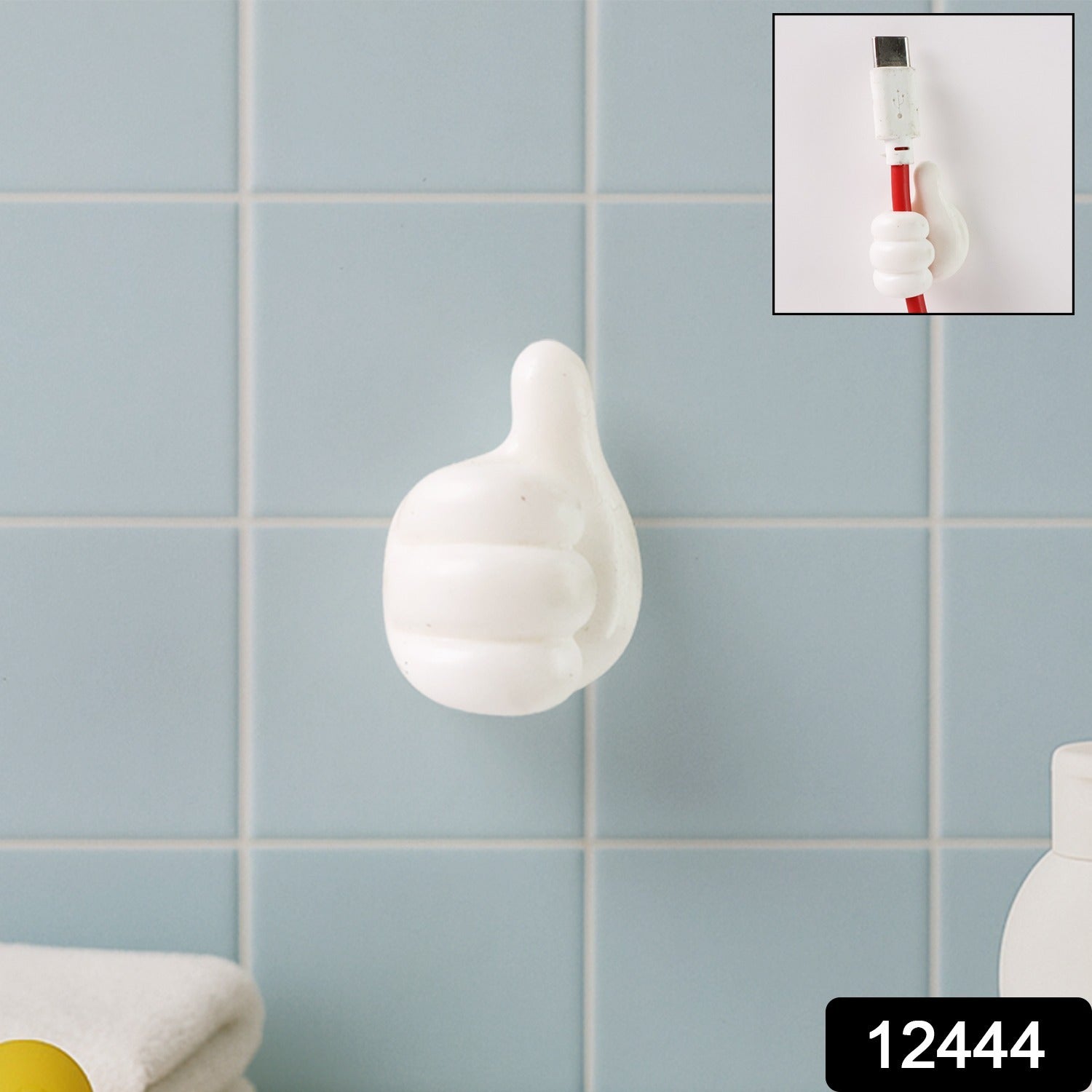Close-up view of white palm-shaped multifunctional cable clip on wall