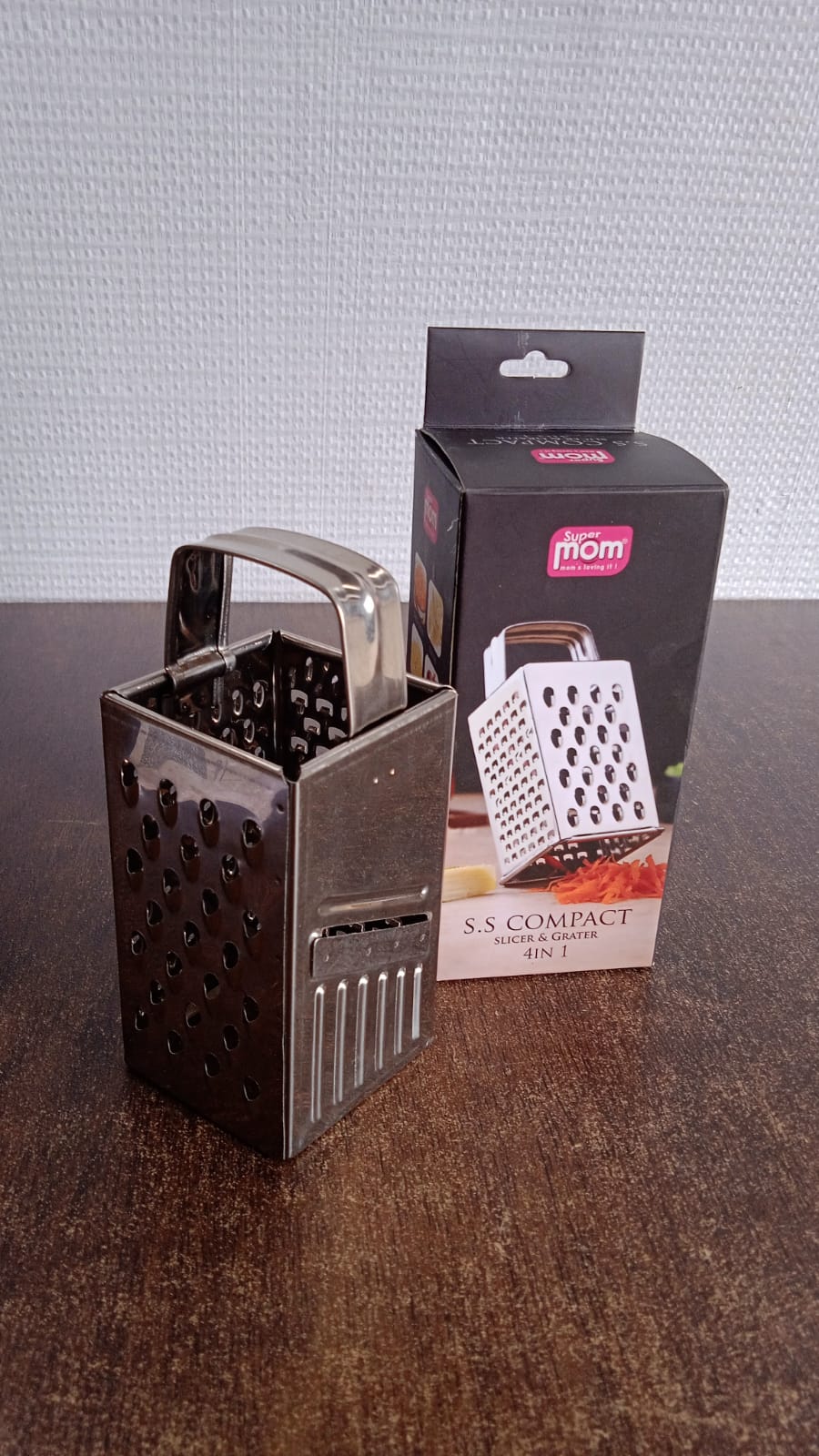 Supermom 4-in-1 stainless steel grater displayed in a home kitchen setup