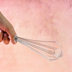 Close-up of balloon wire design on stainless steel hand whisk