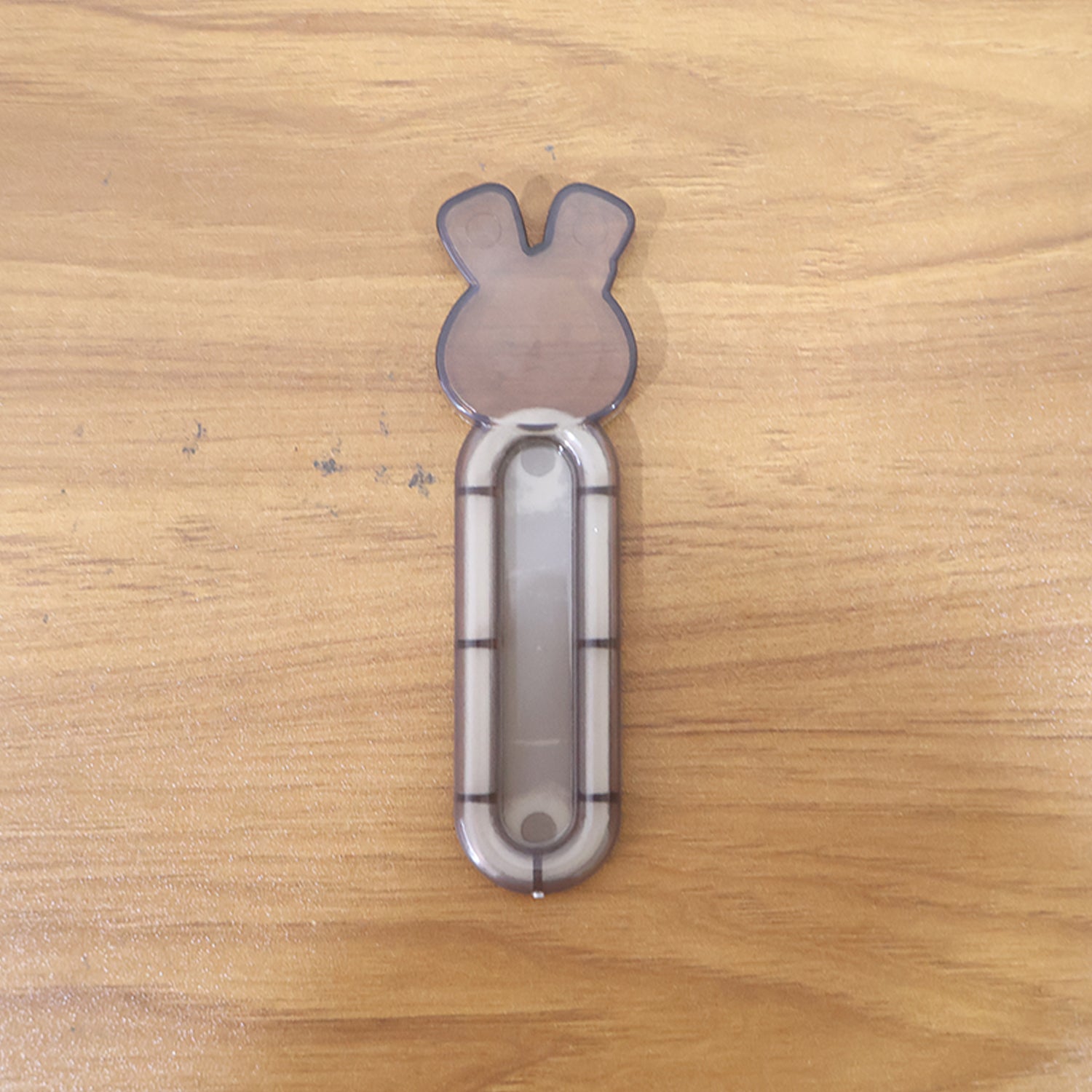 Self stick push pull helper shown firmly attached to cabinet surface