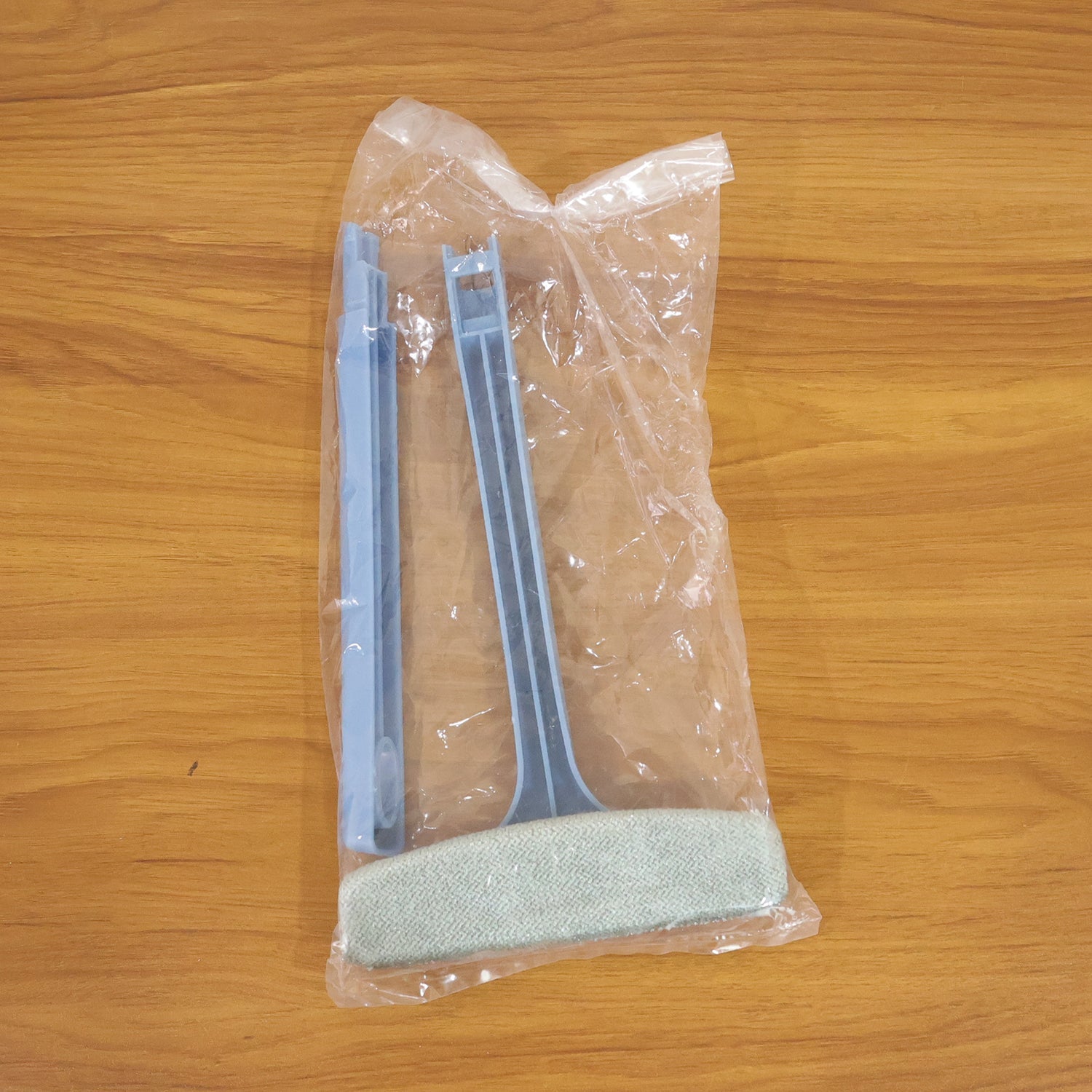 Close-up of the dual-sided brush head on the window mesh cleaning tool.