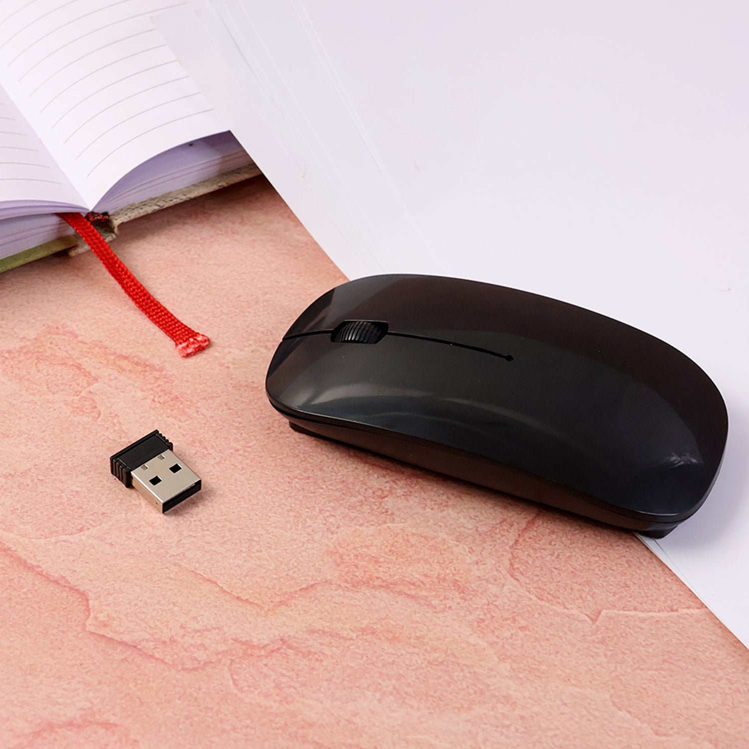 Wireless Mouse displayed next to a hand to show its ultra-thin profile and ergonomic fit.