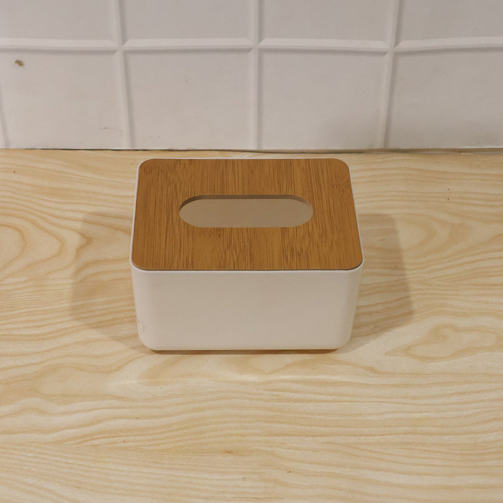 Bamboo tissue box holder on a modern office desk next to a laptop.