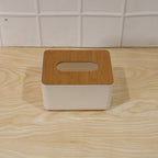Bamboo tissue box holder on a modern office desk next to a laptop.