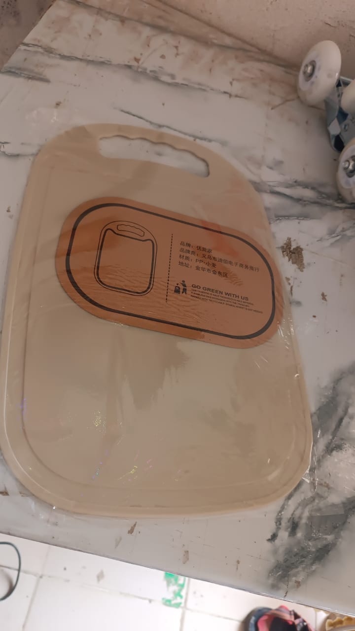 Hand holding lightweight plastic chopping board with handle