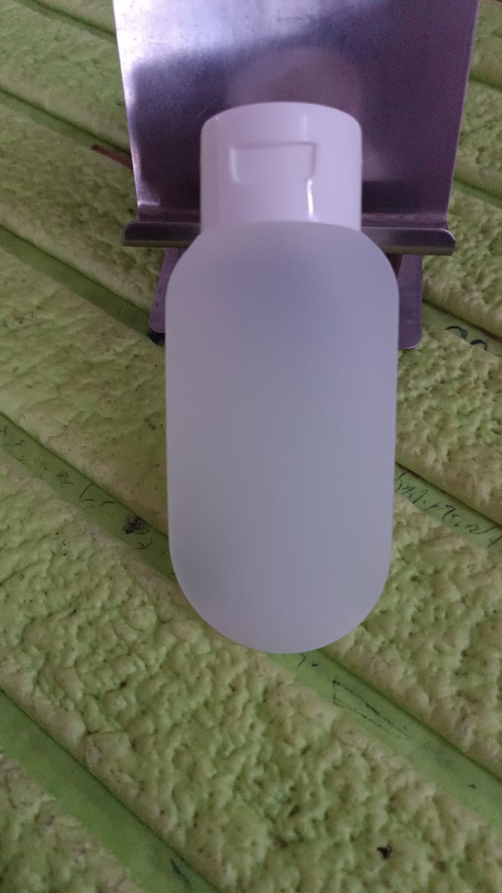 Close-up view of a 60ml travel bottle, showcasing its durable plastic material and secure cap.