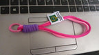 Securely attached multi-color wrist strap lanyard on a smartphone, preventing drops.