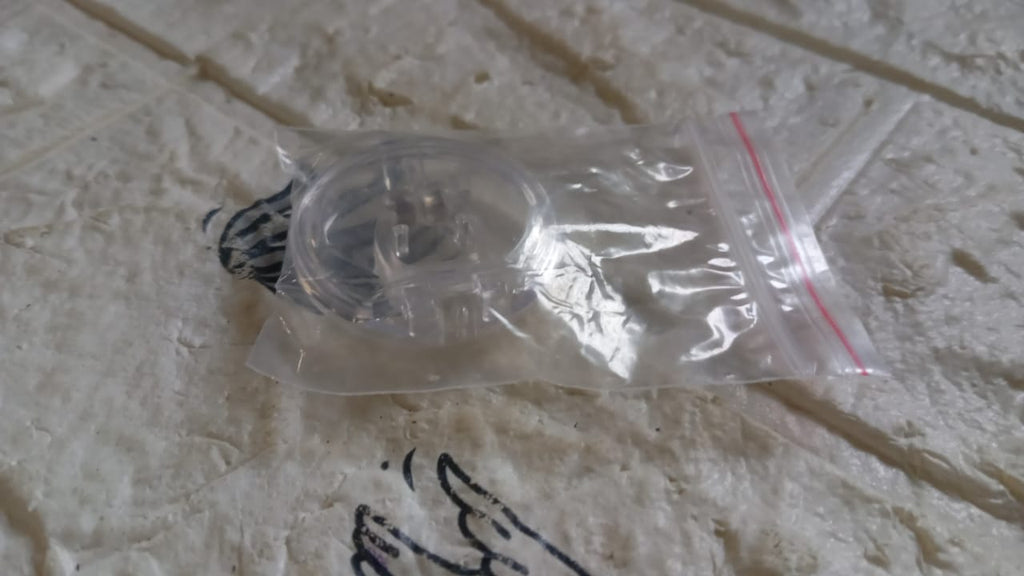 Silicone magnetic nose clip resting on surface before use