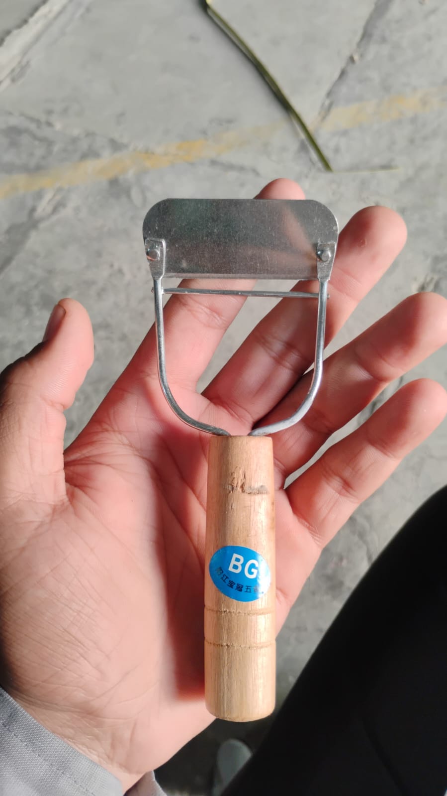 Side view of ergonomic wooden vegetable peeler used in cooking