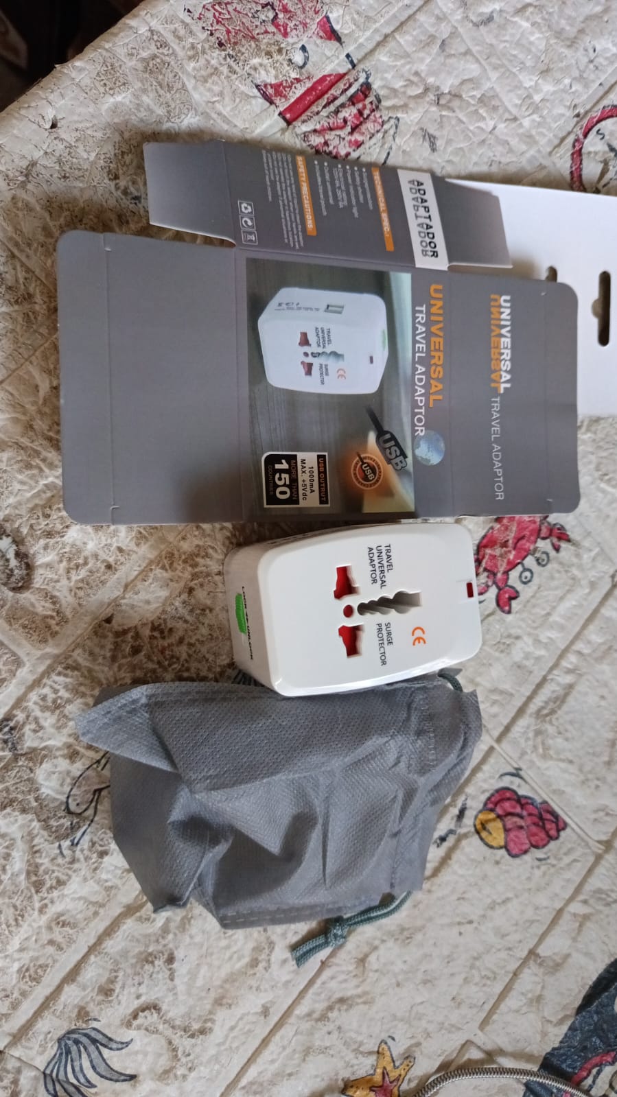 Person using the Poravar Universal Travel Adapter to charge a phone while traveling.