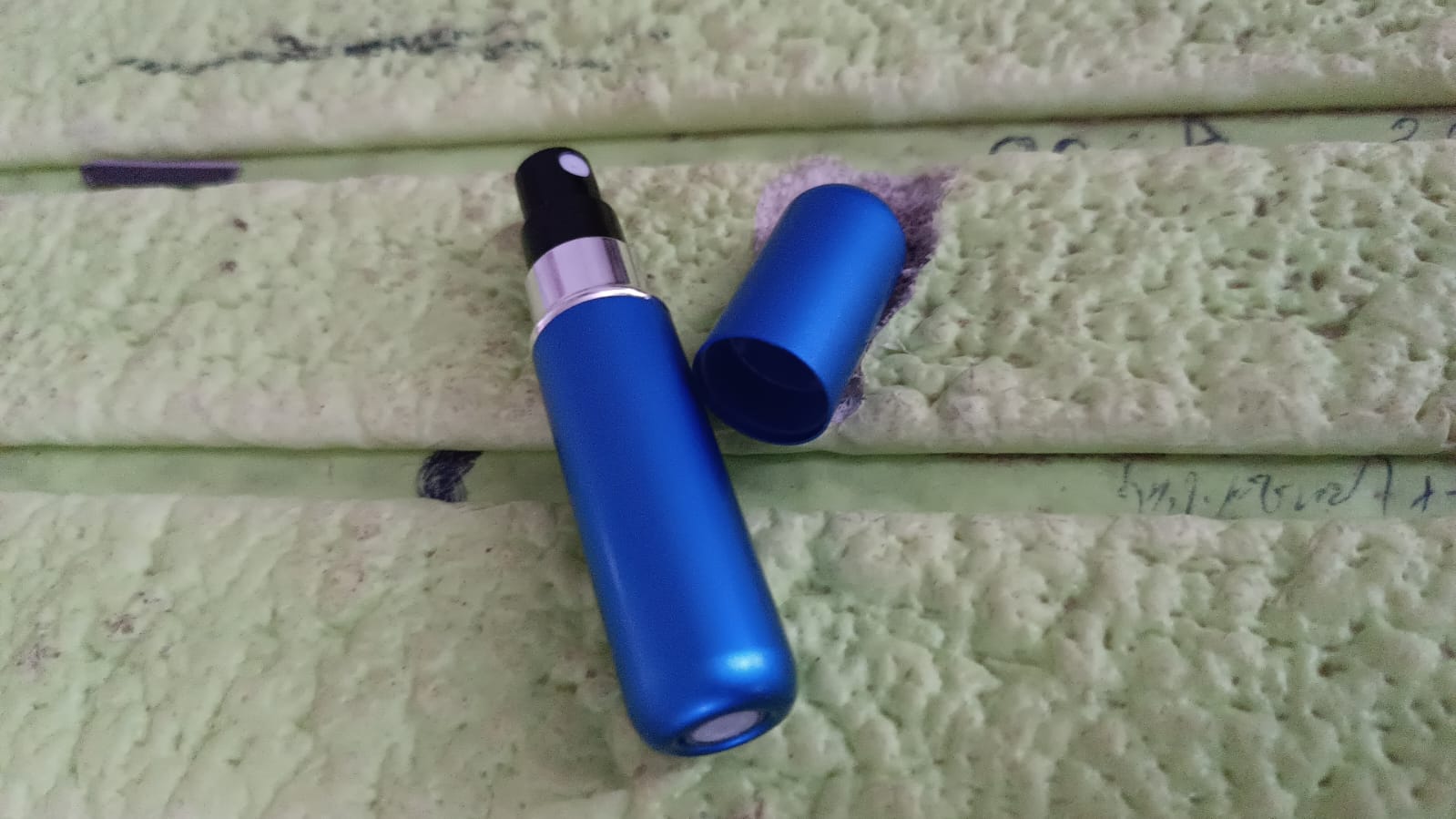 Refilling process shown, with the mini perfume bottle attached to a large bottle.