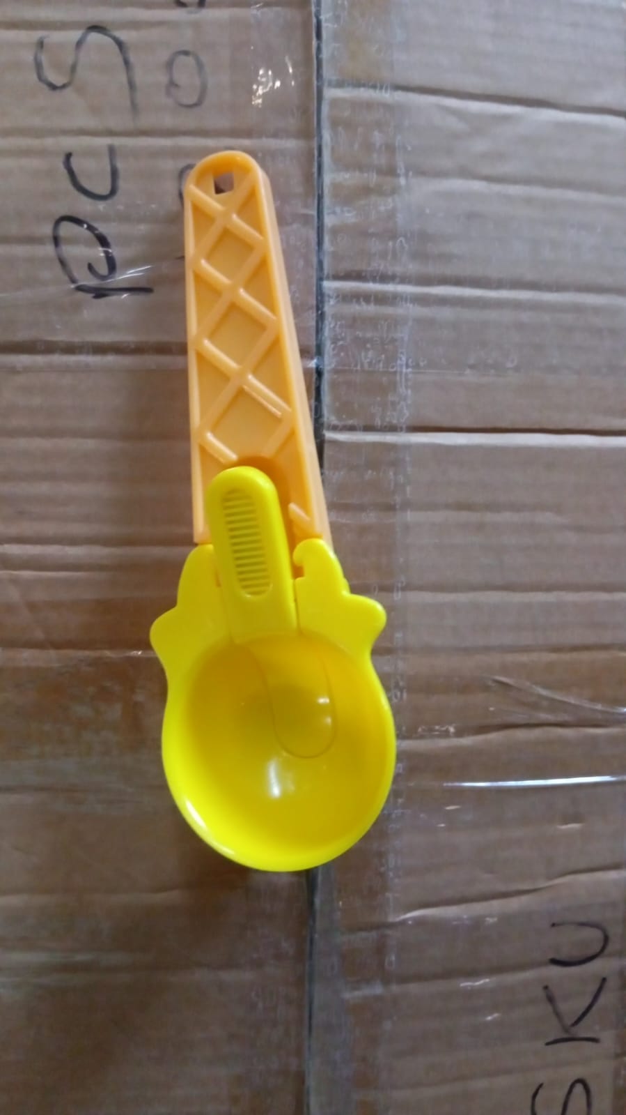 Plastic ice cream & watermelon scooper placed in kitchen environment