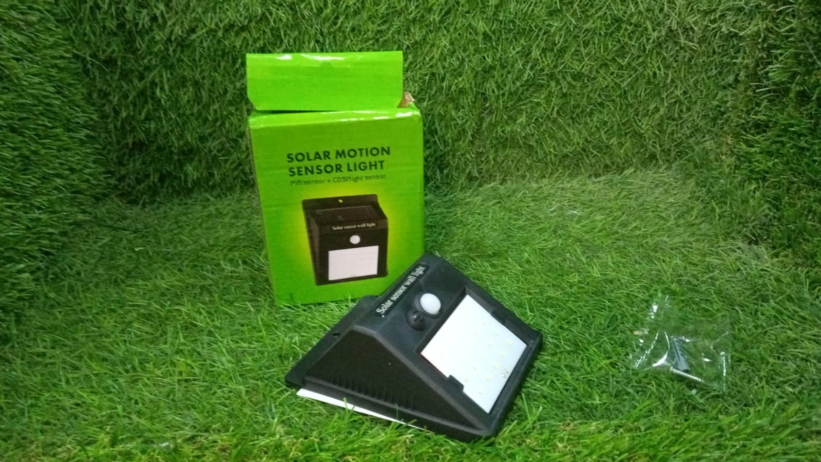 AutoSafeo black solar LED security light installed in a garden setting.