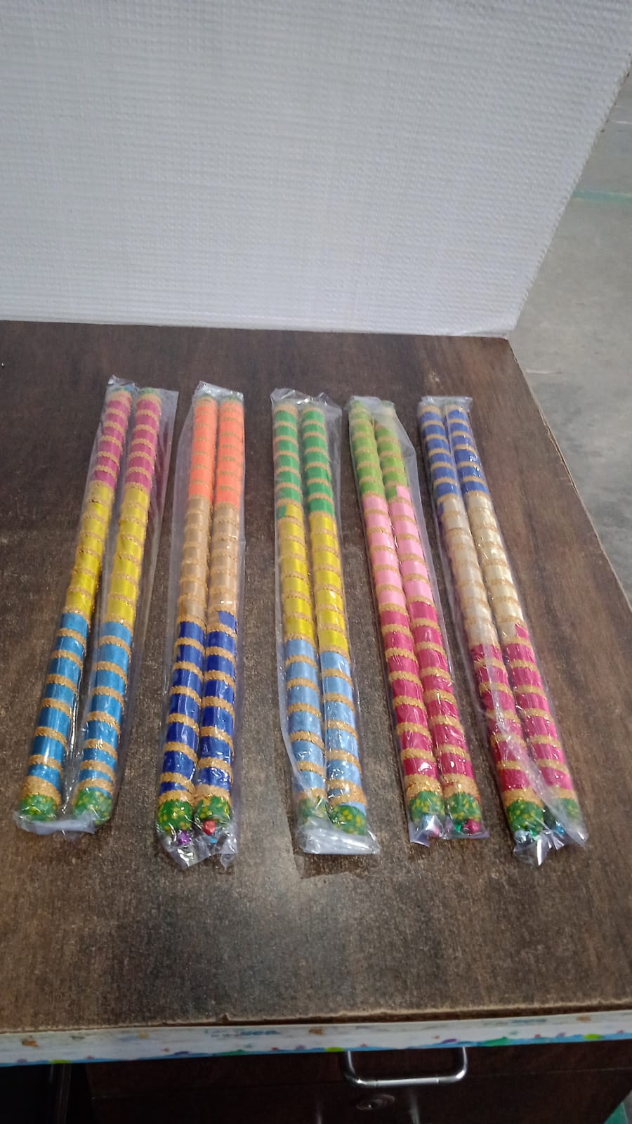Vertical display of decorative dandiya sticks pair for festival dance use