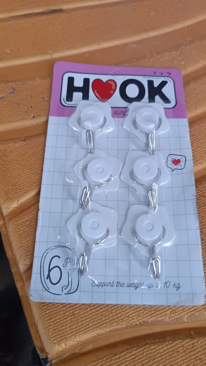 A collection of colorful adhesive hooks demonstrating various uses in a home setting.