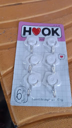 A collection of colorful adhesive hooks demonstrating various uses in a home setting.