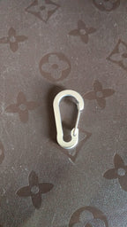 Close-up view of small snap hook clasp showing spring clip