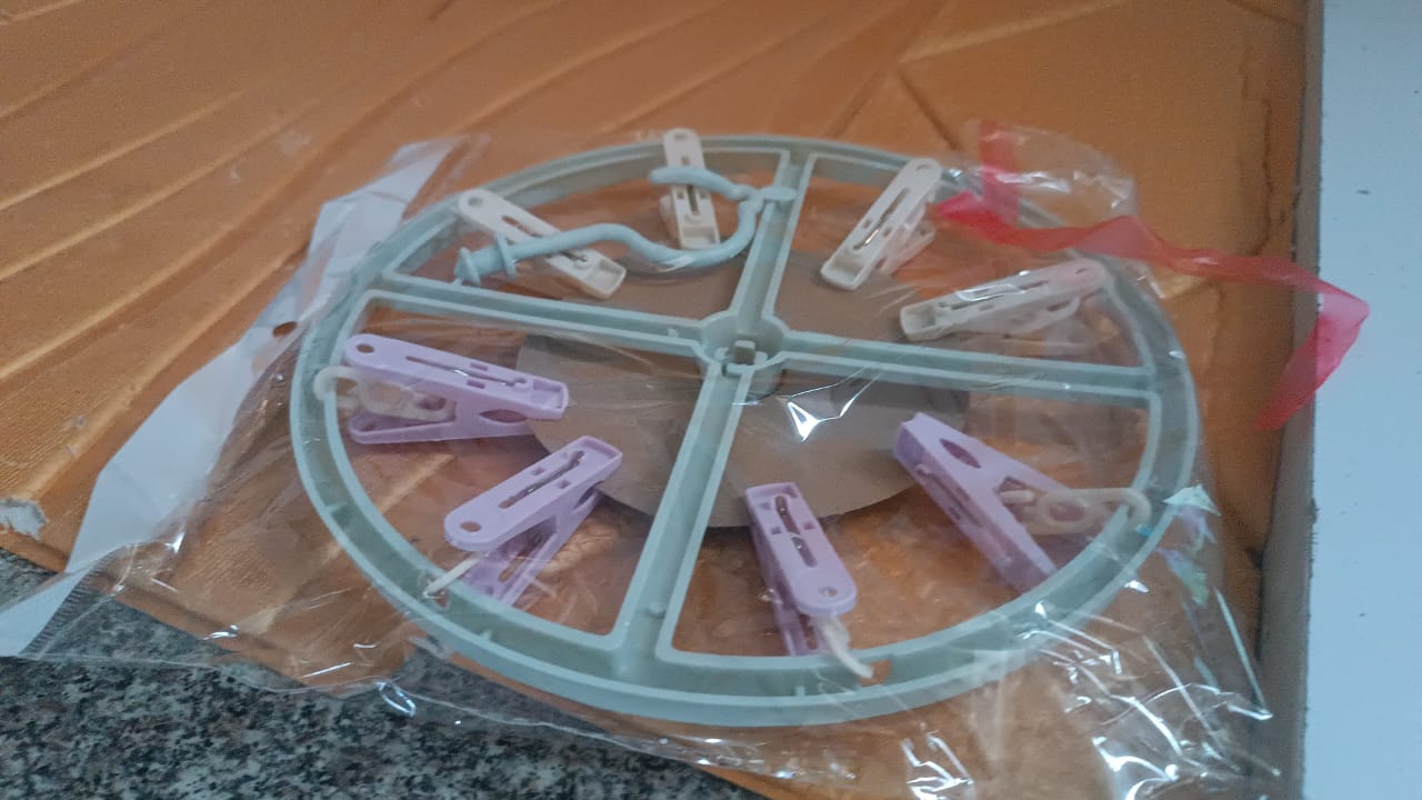 Laundry drying rack with clothespin clips hanging near window