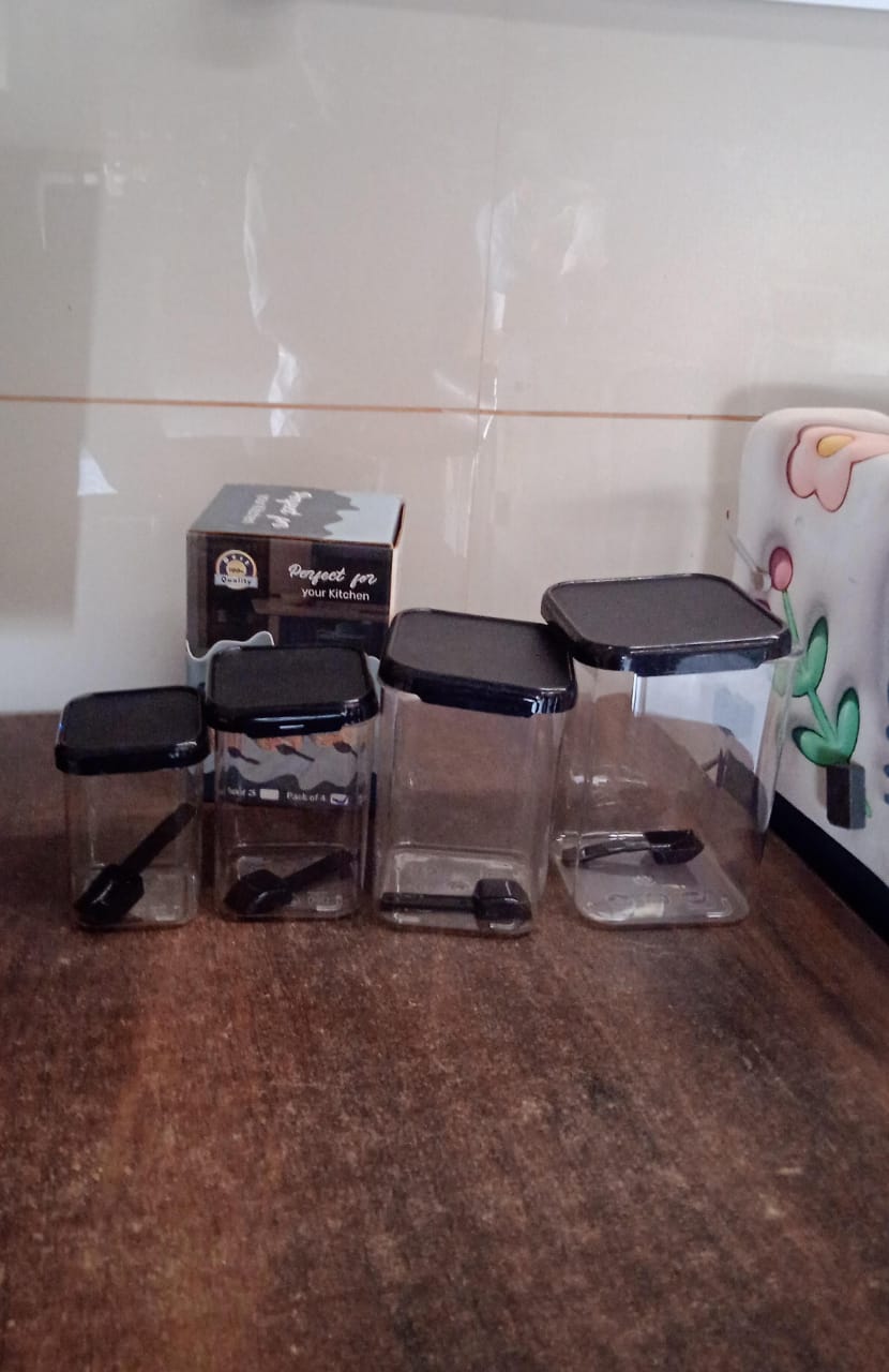 Four air tight plastic containers with included spoons and white lids for kitchen storage