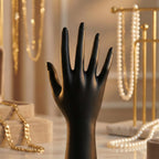 Black mannequin hand jewelry stand displaying assorted accessories