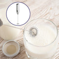 Electric milk frother with whisk attachment, ready for use.