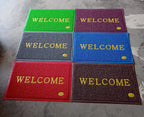 An overhead shot of the Welcome Door Mat in a clean, minimalist home setting.