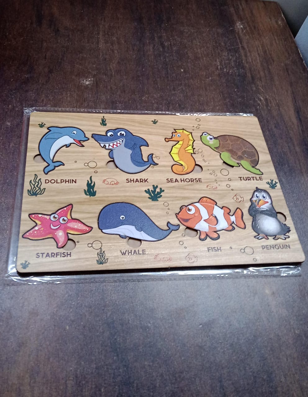 Overhead shot of the educational wooden puzzle with all sea animal pieces in place.