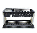Black plastic dish drying rack with water collection tray on a kitchen counter.