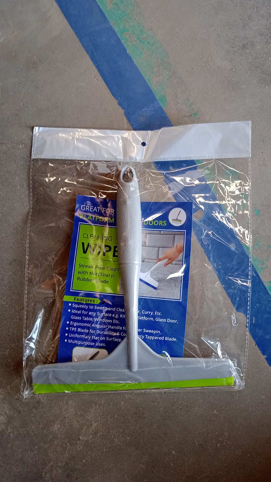 Versatile kitchen wiper being used to clean a car windshield.