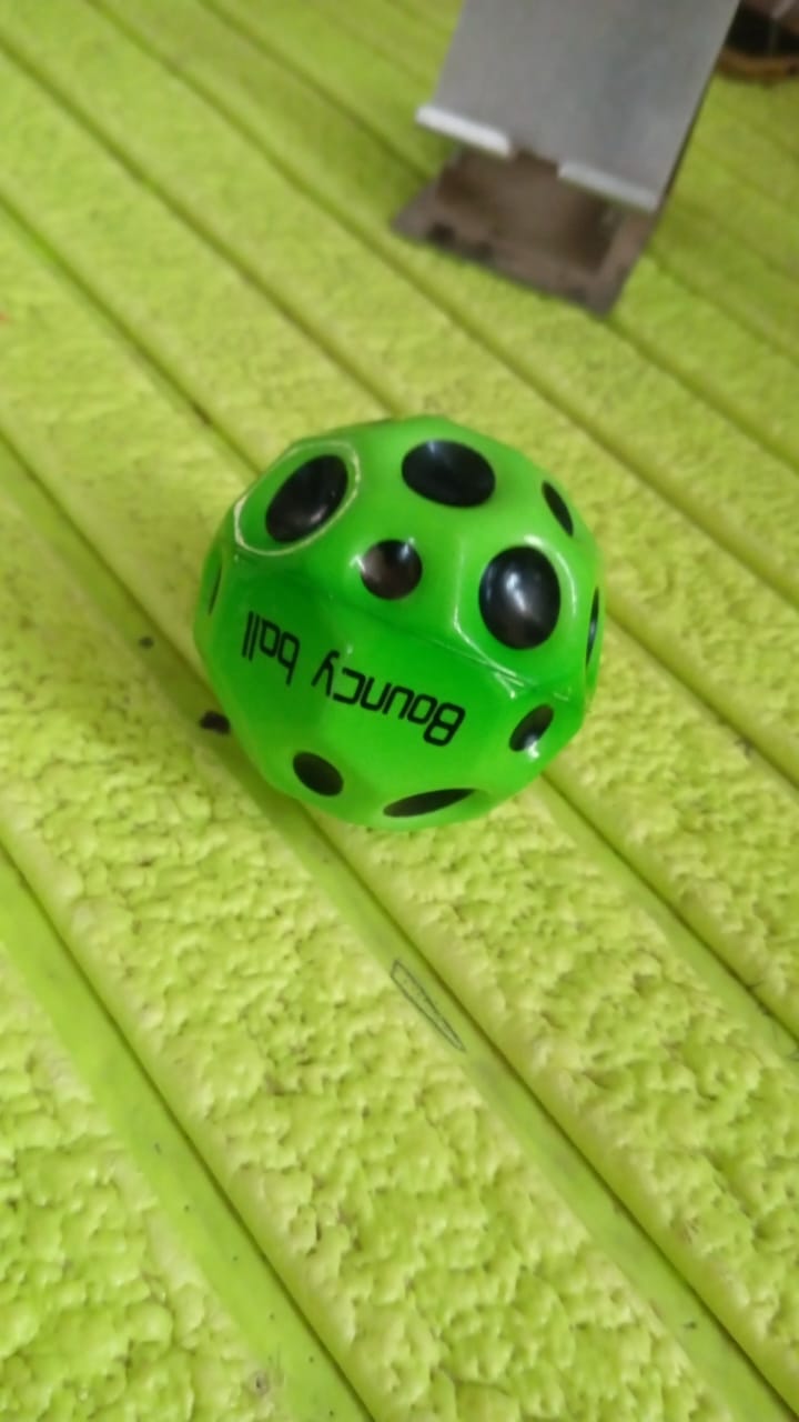 Detailed view of the moon crater texture on a vibrant rubber bouncy ball.