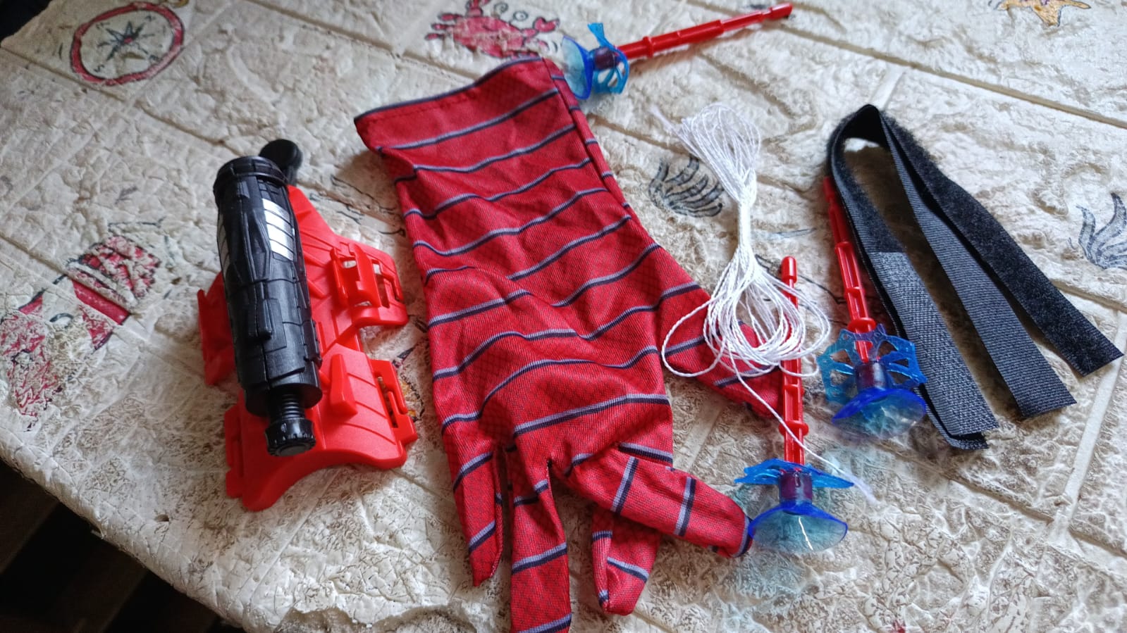 An action shot shows Web Shooter Toy projectiles successfully sticking to a wall.