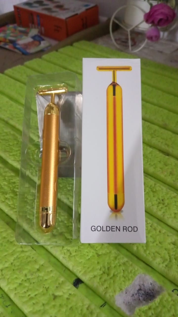 Vibrating facial massage tool in gold finish for skin rejuvenation.