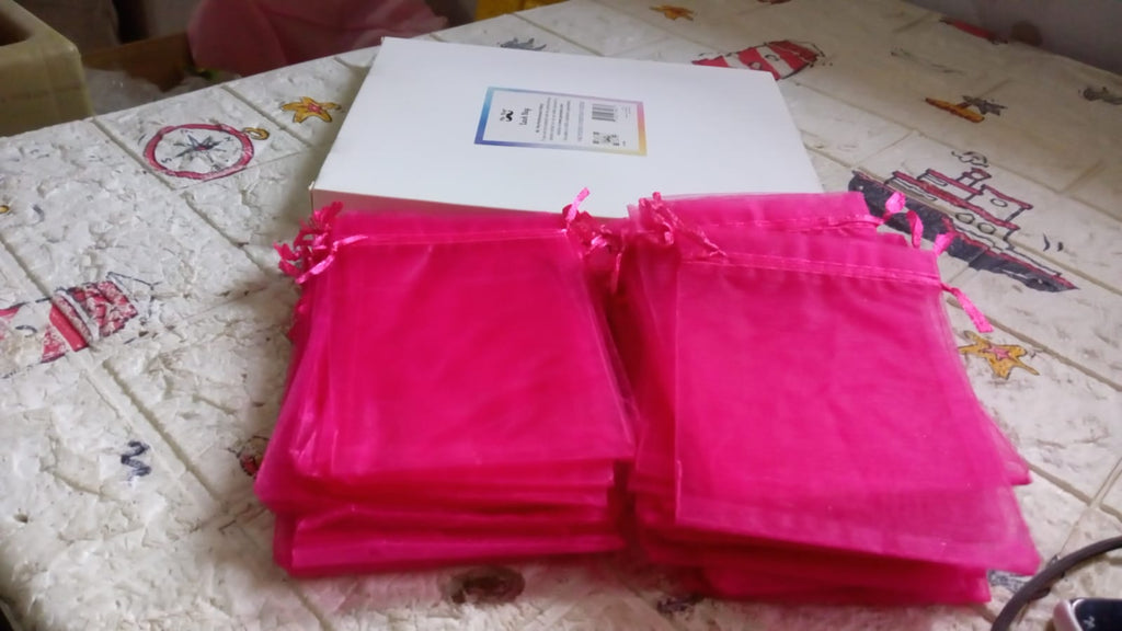 Neatly stacked organza gift bags, highlighting their compact storage and readiness for use.