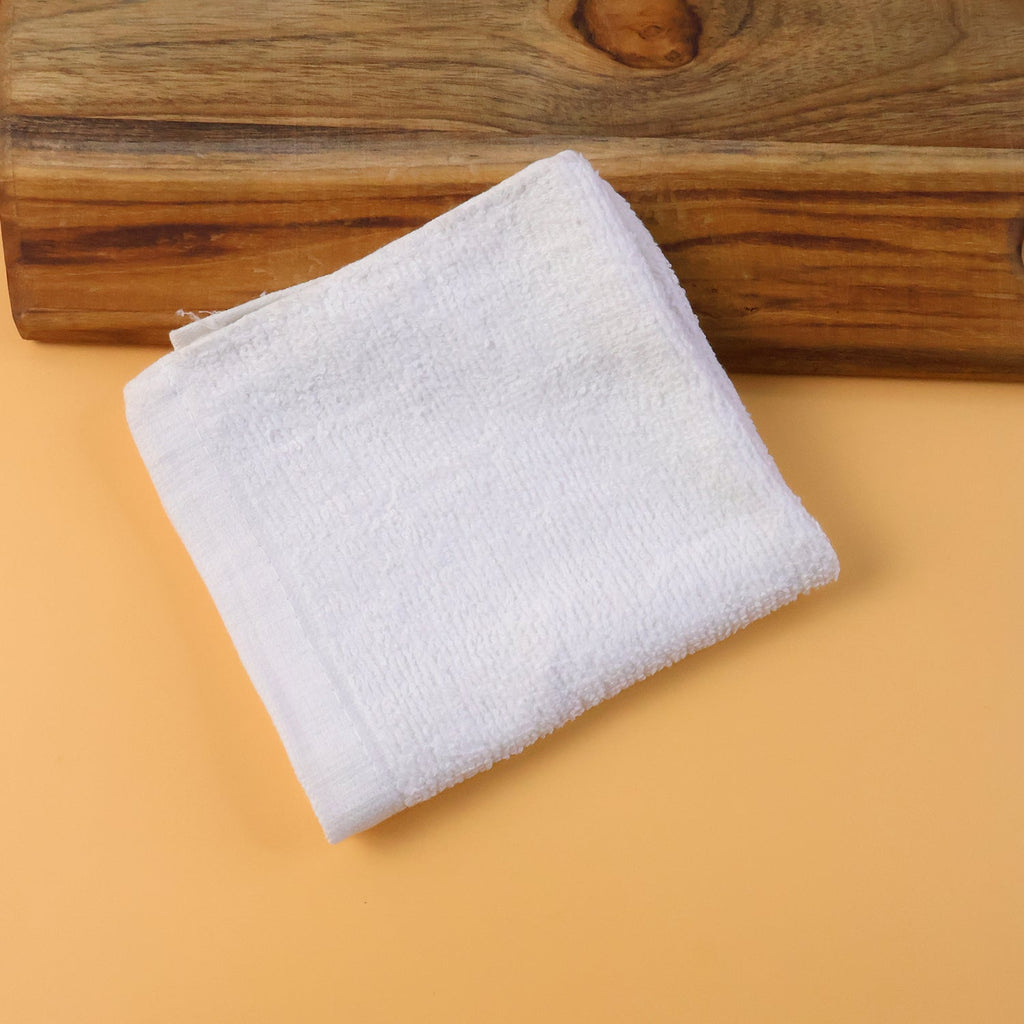 Folded microfiber cleaning cloth placed beside a cleaning spray bottle