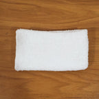 Person cleaning wooden furniture surface with microfiber cloth