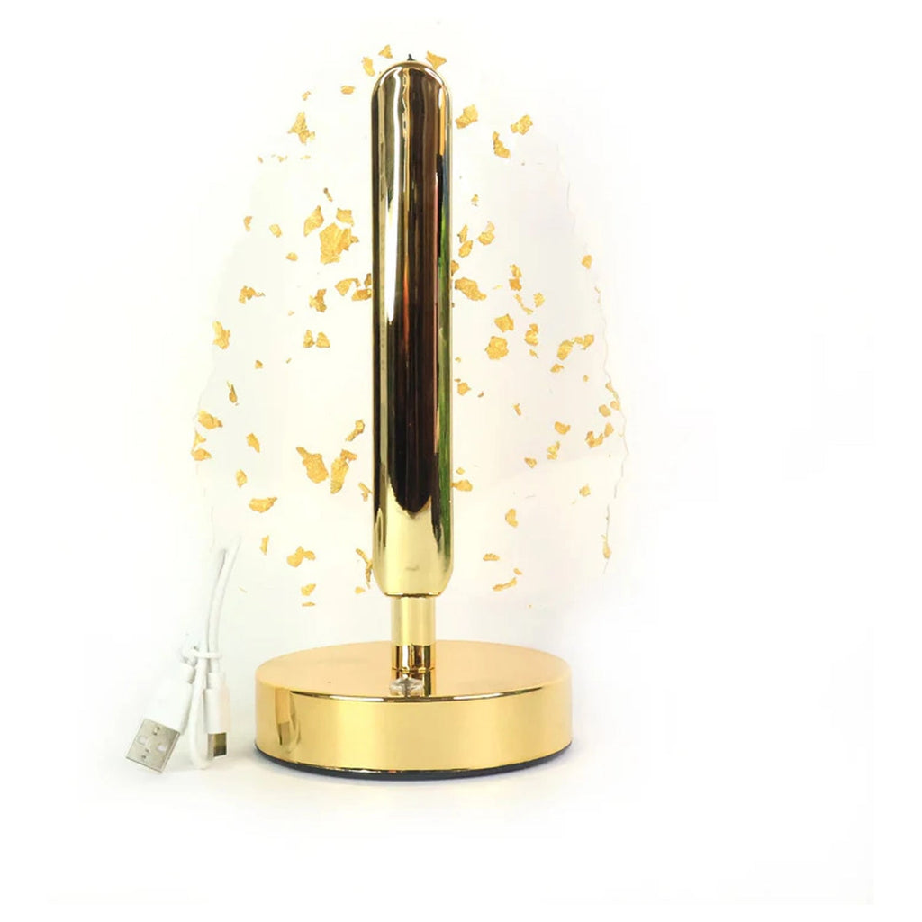 Golden crystal leaf-shaped LED table lamp illuminated on white background