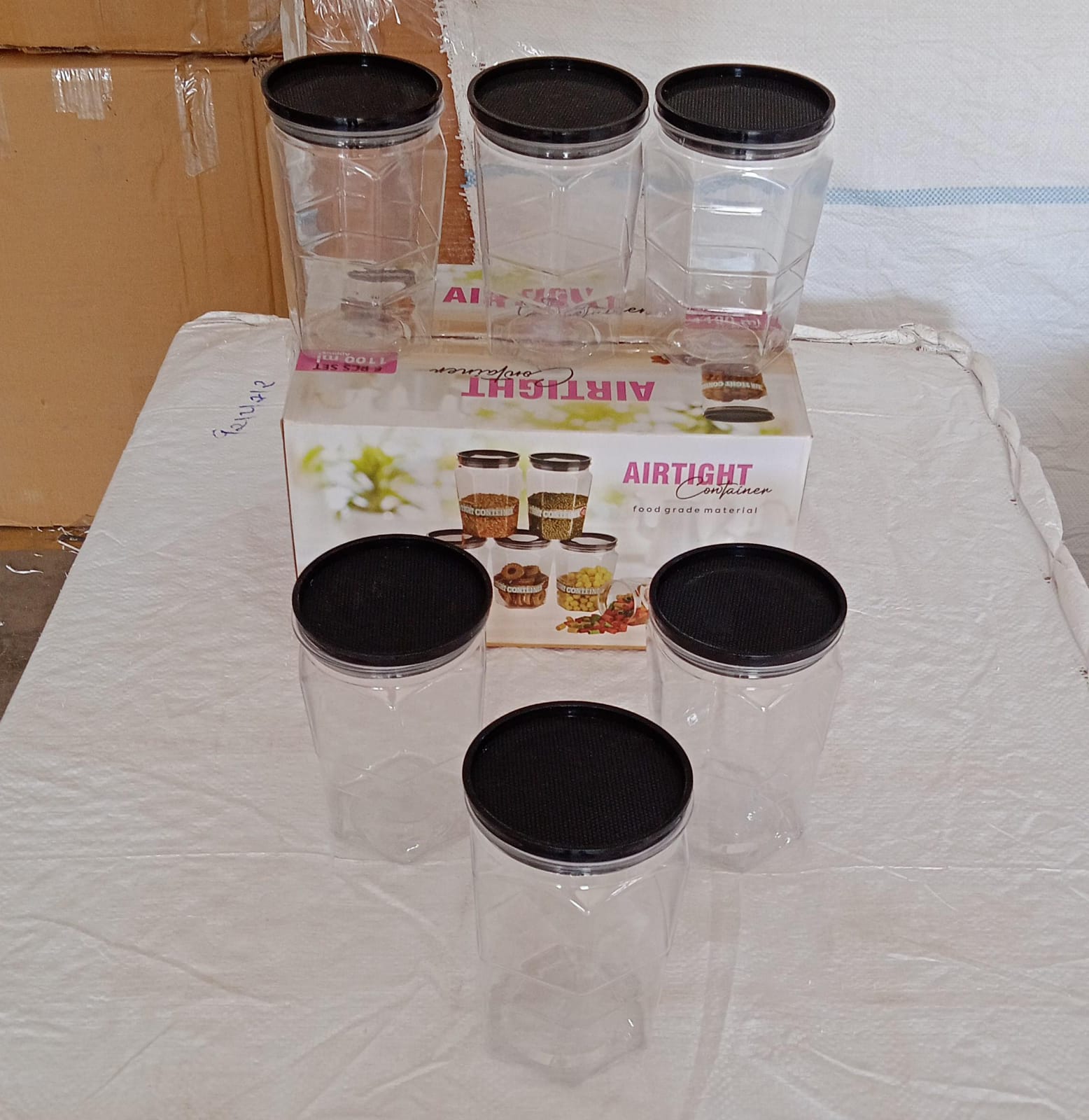 Round kitchen containers holding different dry food items like rice and dal.