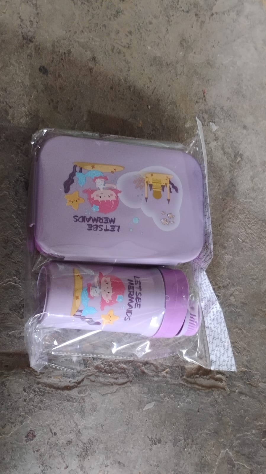 An empty two-compartment tiffin box with the included fork and bottle, ready for packing.